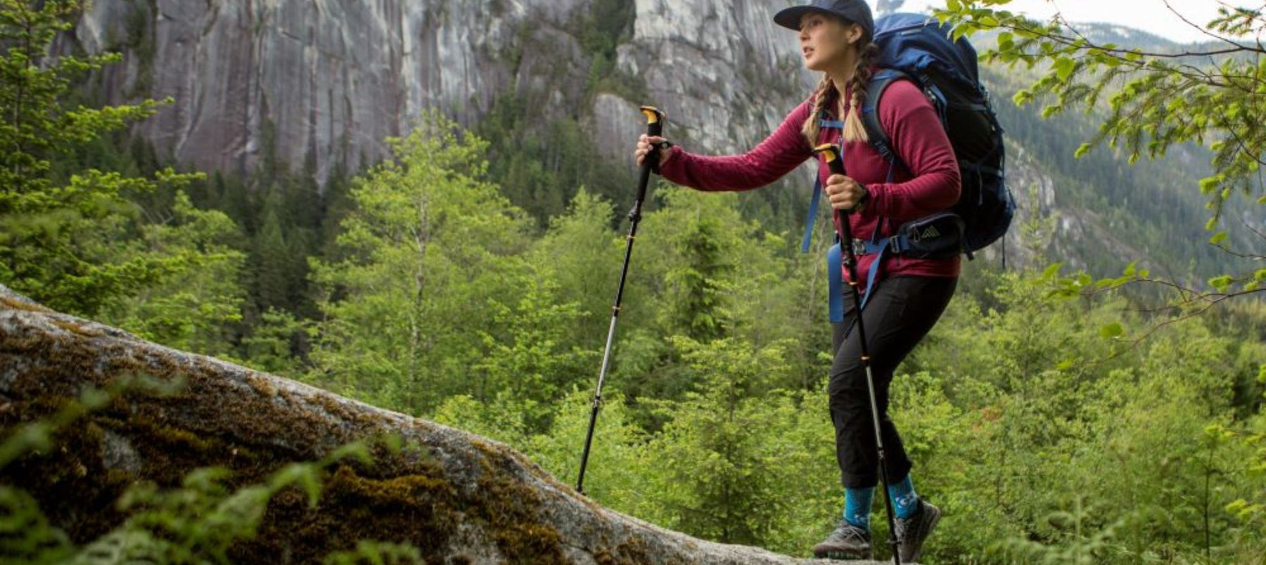 woman hiking with poles and backpack in forest